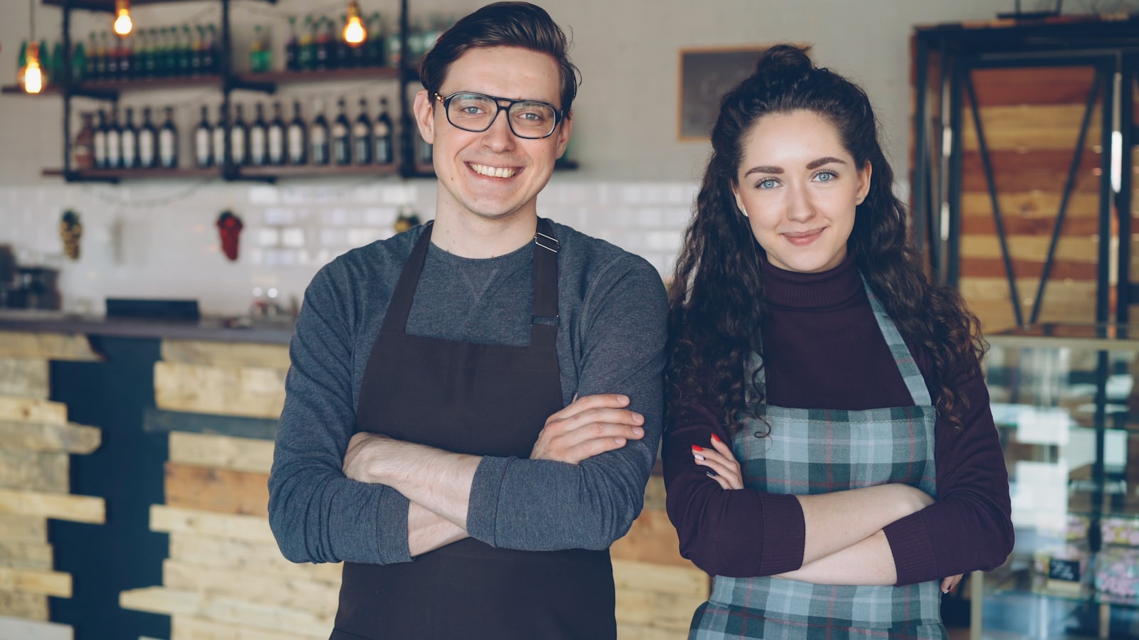 Two small-cafe owners standing together behind their counter