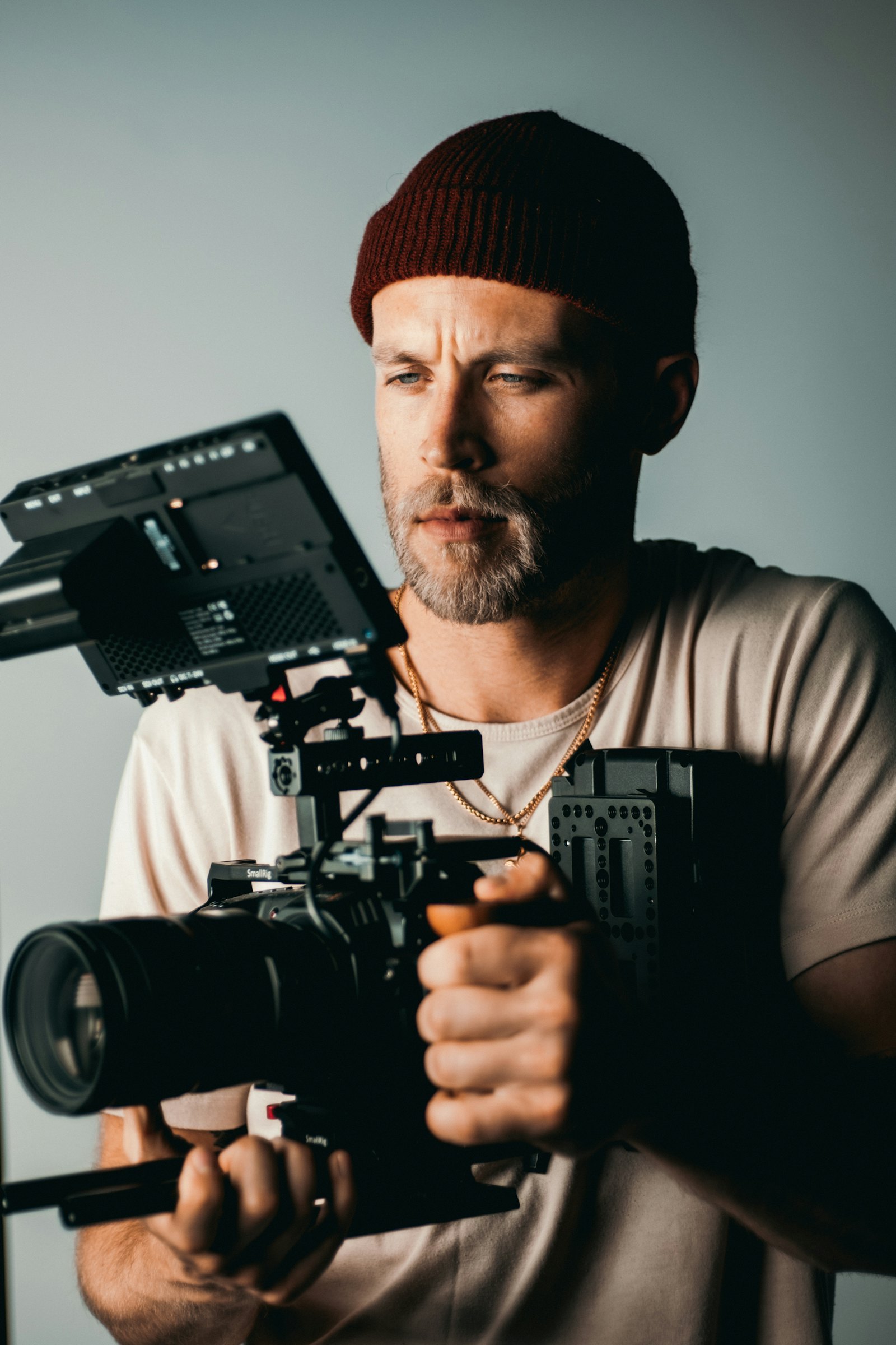 A creator holding a rigged cinema camera, filming in a studio