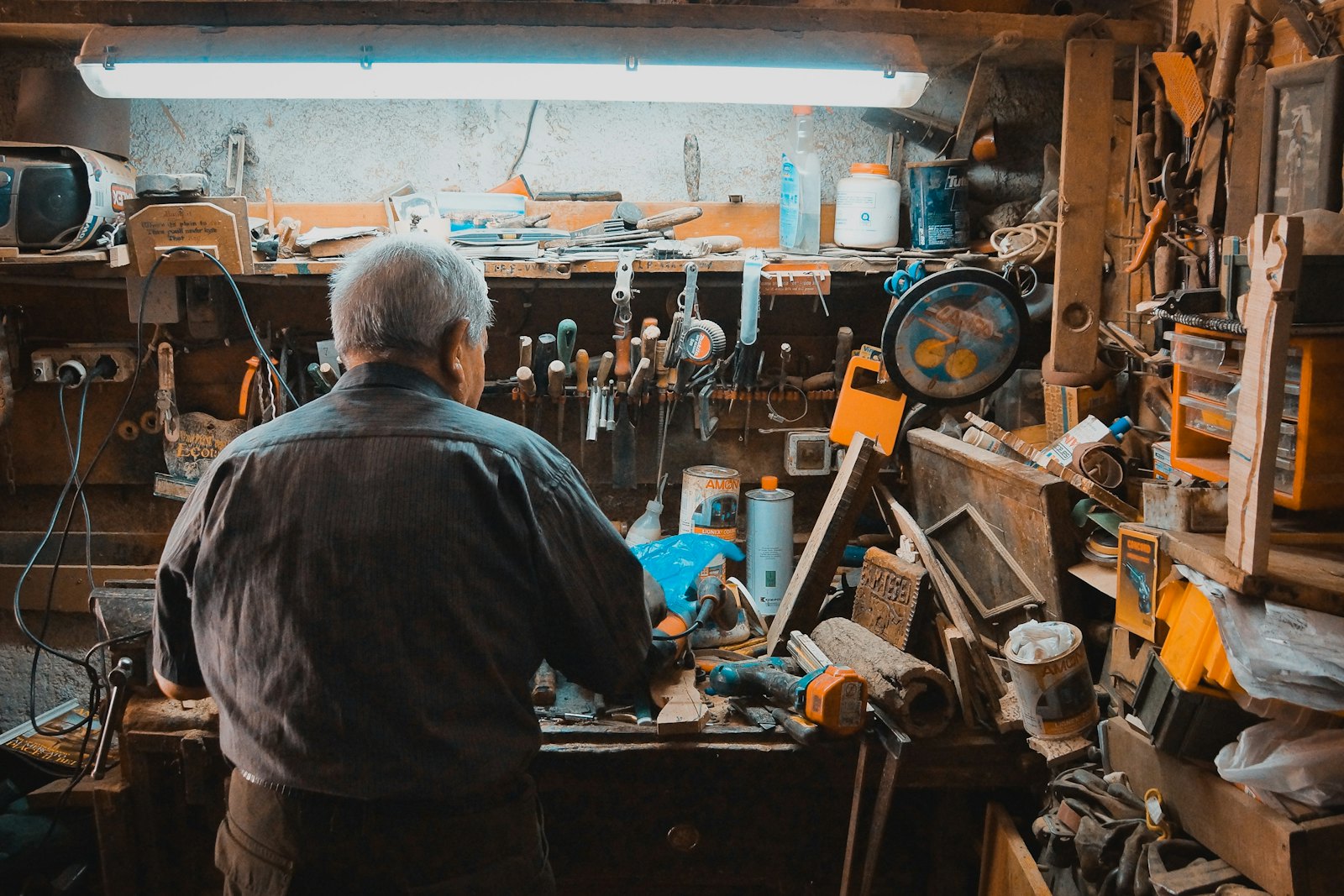 A maker building something by hand at a cluttered workbench
